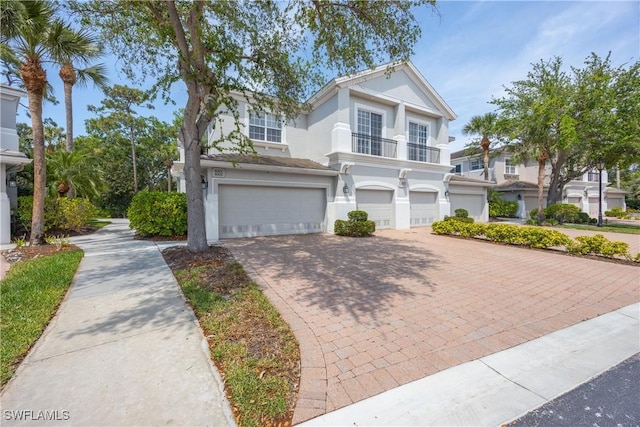 view of front of home featuring decorative driveway, stucco siding, and a garage