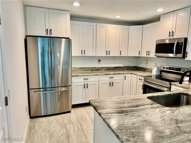 17304 Timber Oak Ln, Fort Myers, FL 33908 - kitchen featuring white cabinetry, recessed lighting, marble finish floor, light stone counters, and appliances with stainless steel finishes
