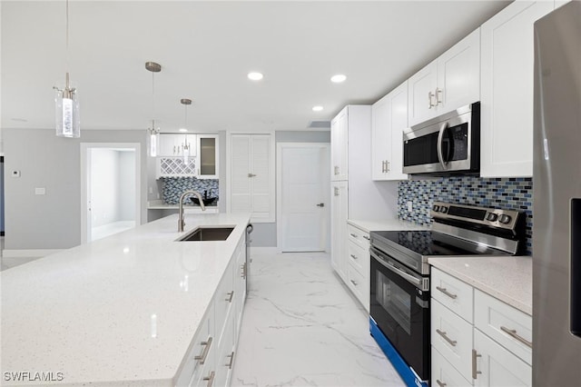 kitchen with tasteful backsplash, a sink, a large island, appliances with stainless steel finishes, and recessed lighting