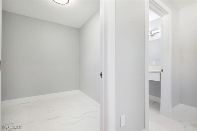 hall with marble finish floor and baseboards