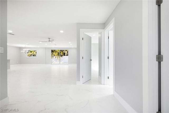corridor featuring an inviting chandelier, baseboards, marble finish floor, and recessed lighting