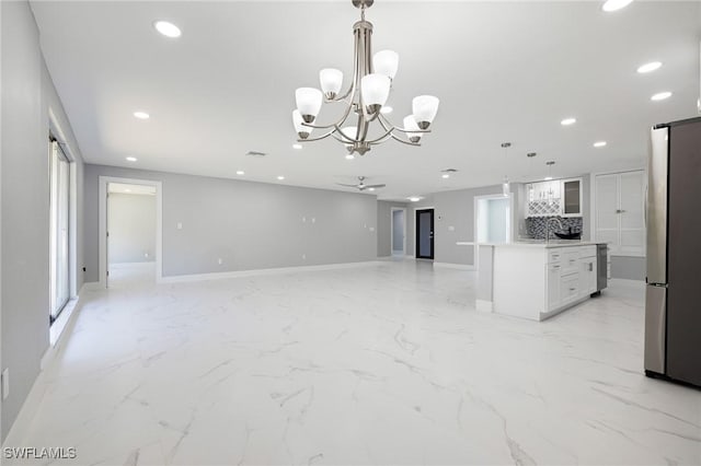 kitchen featuring recessed lighting, marble finish floor, freestanding refrigerator, baseboards, and open floor plan