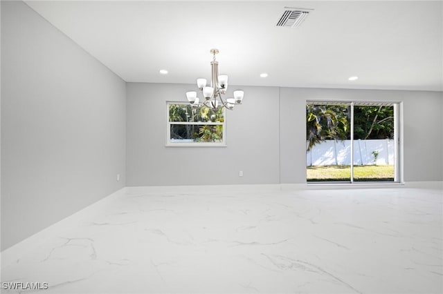 spare room featuring plenty of natural light, visible vents, marble finish floor, and a notable chandelier