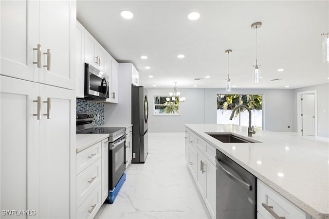 kitchen featuring a sink, pendant lighting, stainless steel appliances, white cabinets, and recessed lighting