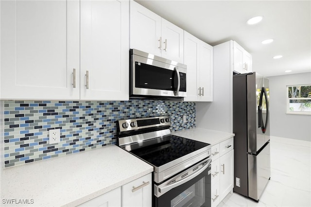 kitchen featuring marble finish floor, stainless steel appliances, white cabinetry, light stone countertops, and recessed lighting