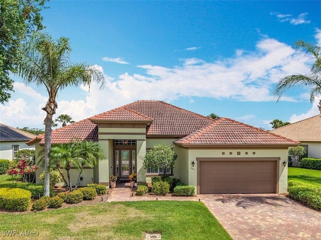13011 Milford Pl, Fort Myers, FL 33913 - mediterranean / spanish-style home with decorative driveway, a tile roof, stucco siding, and a garage