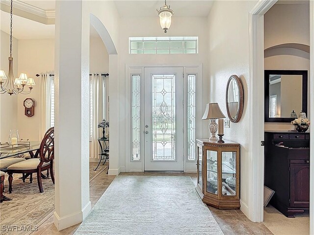 13011 Milford Pl, Fort Myers, FL 33913 - foyer with arched walkways, baseboards, and a notable chandelier