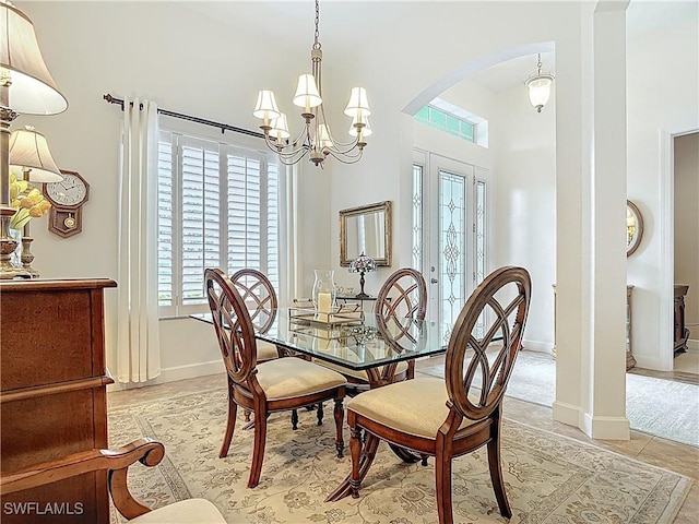 13011 Milford Pl, Fort Myers, FL 33913 - dining space with an inviting chandelier, light tile patterned floors, arched walkways, and baseboards