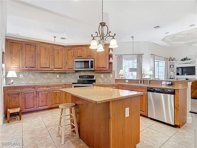 13011 Milford Pl, Fort Myers, FL 33913 - kitchen with a sink, tasteful backsplash, appliances with stainless steel finishes, and a peninsula