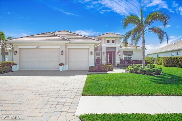 14364 Neptune Ave, Naples, FL 34114 - view of front facade featuring decorative driveway, an attached garage, stucco siding, a front lawn, and a tile roof