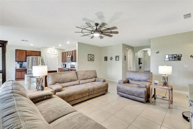 2701 NW Embers Ter, Cape Coral, FL 33993 - living area featuring light tile patterned flooring, a ceiling fan, baseboards, visible vents, and arched walkways