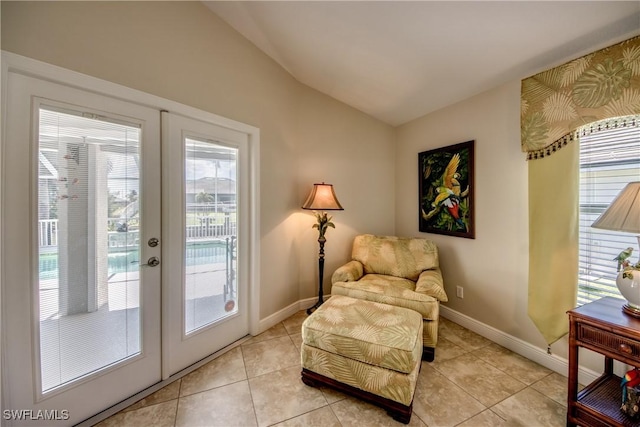 living area with french doors, baseboards, and lofted ceiling
