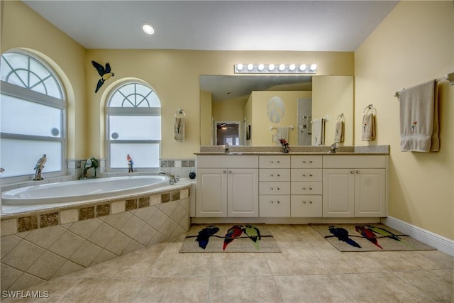 bathroom featuring double vanity, a sink, a garden tub, and tile patterned flooring