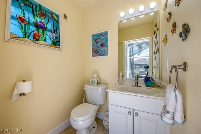half bathroom with baseboards, toilet, and vanity