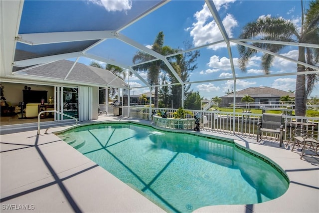 pool featuring glass enclosure, fence, and a patio area