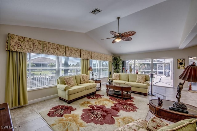 living area with tile patterned flooring, lofted ceiling, baseboards, ceiling fan, and visible vents