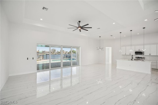203 Old Burnt Store Rd S, Cape Coral, FL 33991 - unfurnished living room with visible vents, a raised ceiling, a ceiling fan, recessed lighting, and a towering ceiling