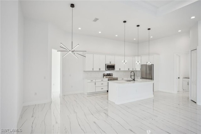 203 Old Burnt Store Rd S, Cape Coral, FL 33991 - kitchen featuring a towering ceiling, baseboards, white cabinetry, stainless steel appliances, and a sink