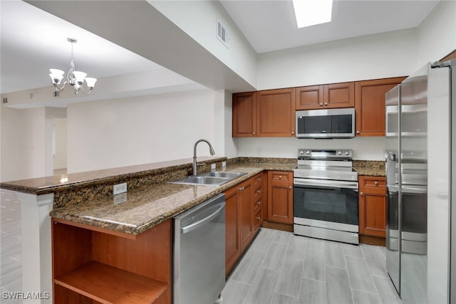 kitchen with a peninsula, open shelves, brown cabinetry, appliances with stainless steel finishes, and a sink