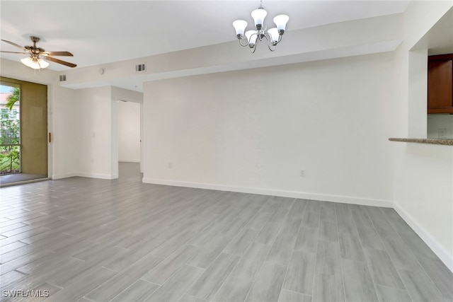 unfurnished living room with light wood-style floors, visible vents, ceiling fan with notable chandelier, and baseboards