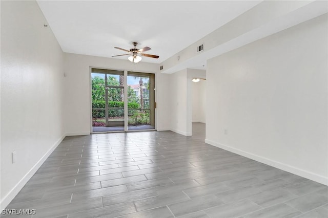 empty room featuring light wood finished floors, visible vents, baseboards, and a ceiling fan