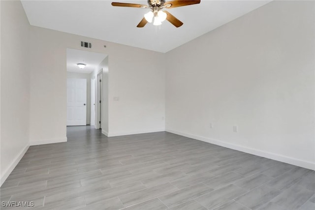 spare room with light wood-style floors, ceiling fan, baseboards, and visible vents