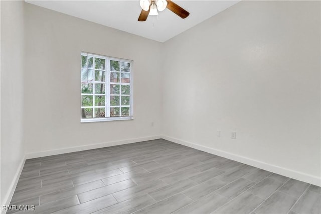 empty room featuring ceiling fan, baseboards, and wood tiled floor