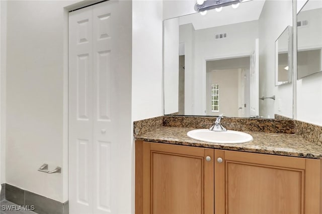 bathroom featuring vanity, visible vents, and a closet