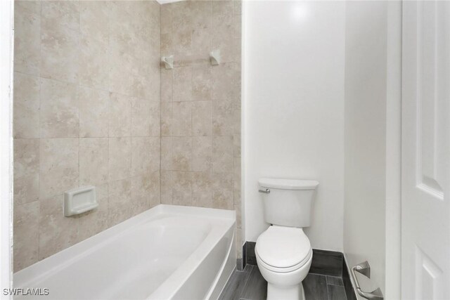 full bath with toilet and baseboards