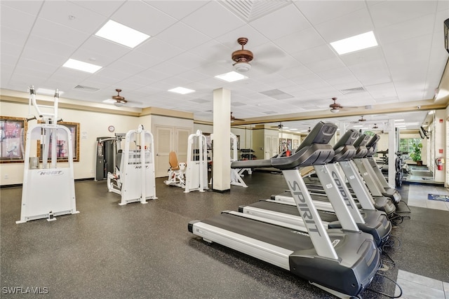 exercise room featuring a paneled ceiling, ceiling fan, and visible vents