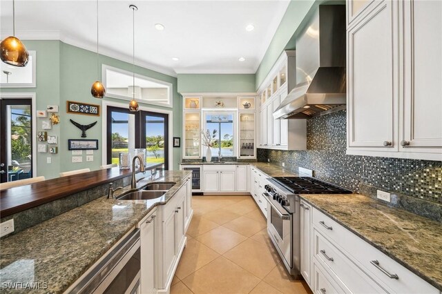 3911 Lakemont Dr, Bonita Springs, FL 34134 - kitchen with tasteful backsplash, wine cooler, stainless steel range, a sink, and wall chimney range hood