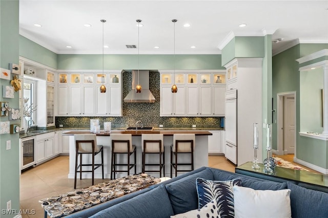 3911 Lakemont Dr, Bonita Springs, FL 34134 - kitchen with an island with sink, paneled built in refrigerator, beverage cooler, open floor plan, and wall chimney range hood