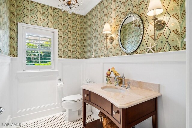 3911 Lakemont Dr, Bonita Springs, FL 34134 - half bathroom with a wainscoted wall, vanity, toilet, and wallpapered walls