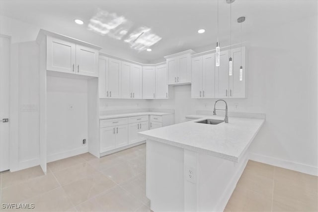 150 Bell Blvd S, Lehigh Acres, FL 33974 - kitchen featuring light tile patterned floors, white cabinets, a sink, and a peninsula