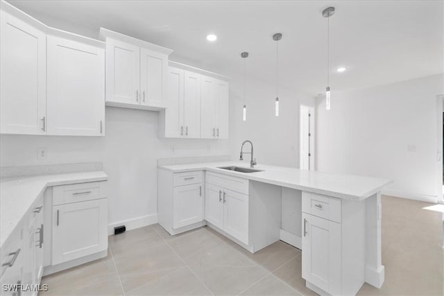 150 Bell Blvd S, Lehigh Acres, FL 33974 - kitchen with a sink, white cabinetry, a peninsula, hanging light fixtures, and recessed lighting
