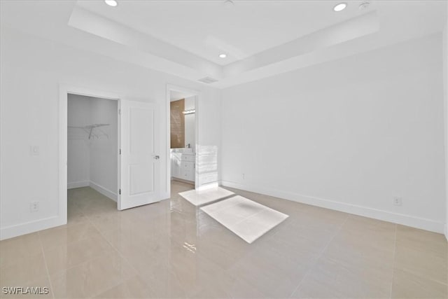 150 Bell Blvd S, Lehigh Acres, FL 33974 - unfurnished bedroom with a raised ceiling, a walk in closet, baseboards, and recessed lighting