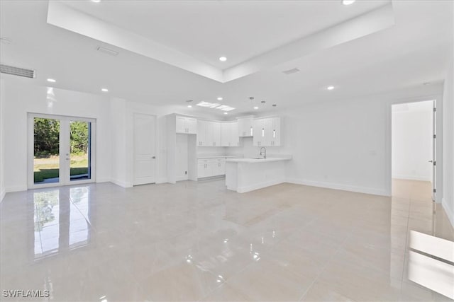 150 Bell Blvd S, Lehigh Acres, FL 33974 - unfurnished living room with recessed lighting, french doors, baseboards, a raised ceiling, and a sink