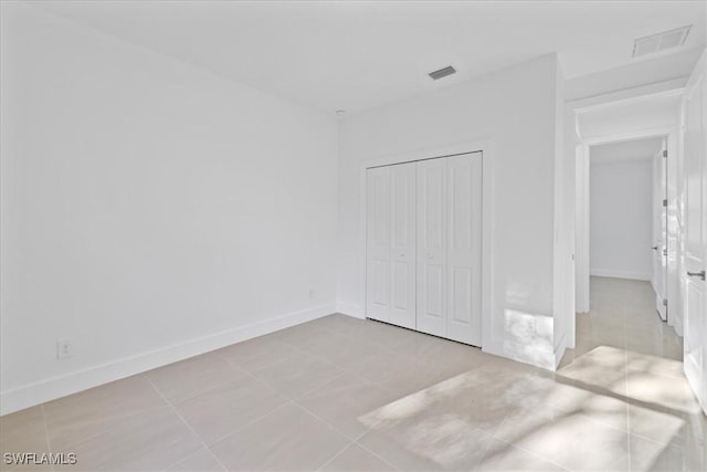 150 Bell Blvd S, Lehigh Acres, FL 33974 - unfurnished bedroom featuring baseboards, visible vents, a closet, and tile patterned floors
