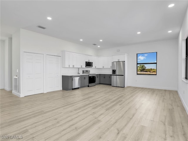 633 Cane St E, Lehigh Acres, FL 33974 - kitchen featuring stainless steel appliances, light wood-type flooring, recessed lighting, light countertops, and white cabinets