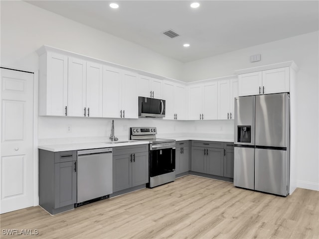 633 Cane St E, Lehigh Acres, FL 33974 - kitchen featuring appliances with stainless steel finishes, gray cabinetry, light countertops, white cabinets, and recessed lighting