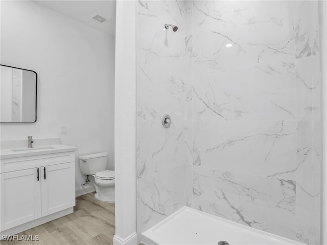 633 Cane St E, Lehigh Acres, FL 33974 - full bathroom with vanity, toilet, wood finished floors, and a marble finish shower