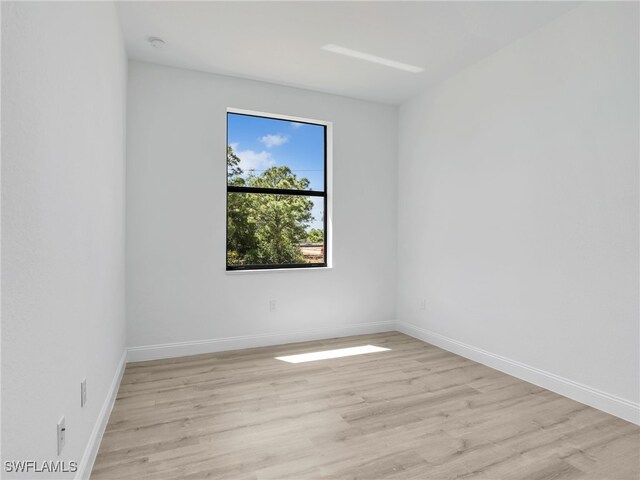 633 Cane St E, Lehigh Acres, FL 33974 - empty room featuring light wood-style floors, baseboards, and a smoke detector