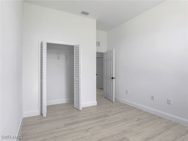 633 Cane St E, Lehigh Acres, FL 33974 - unfurnished bedroom with light wood finished floors, baseboards, and a closet
