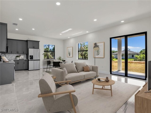 633 Cane St E, Lehigh Acres, FL 33974 - living room featuring recessed lighting and light marble finish flooring