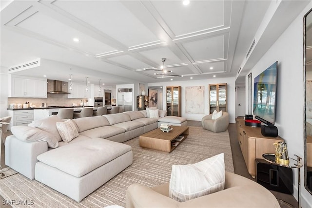 living area featuring coffered ceiling and recessed lighting