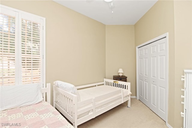 carpeted bedroom featuring a closet and ceiling fan