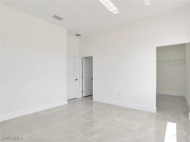 1134 Cumming St E, Lehigh Acres, FL 33974 - unfurnished bedroom featuring baseboards, a spacious closet, and a closet