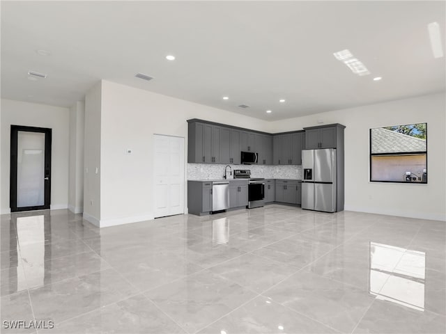 1134 Cumming St E, Lehigh Acres, FL 33974 - kitchen with appliances with stainless steel finishes, light marble finish floors, a sink, decorative backsplash, and light countertops