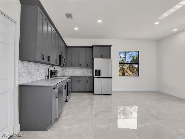 1134 Cumming St E, Lehigh Acres, FL 33974 - kitchen with appliances with stainless steel finishes, light countertops, backsplash, recessed lighting, and gray cabinetry