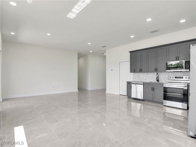 1134 Cumming St E, Lehigh Acres, FL 33974 - kitchen with stainless steel appliances, recessed lighting, tasteful backsplash, open floor plan, and a sink